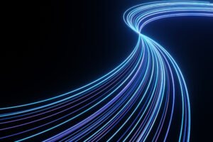 Blue and purple light trails moving across a black background. Illustration as background for the topics of technology, optical fibre and fast telecommunication
